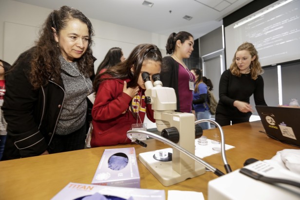 Marina Gomez observa a su hija Arizbel practicar con el microscopio.